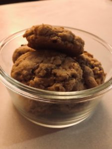 freshly baked chocolate chip cookies stacked in a clear bowl